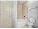 Bathroom features a tub, neutral tile, and a door with coat hooks at 1199 Lavista Ne Rd, Atlanta, GA 30324