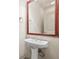 A powder room featuring a pedestal sink, large mirror, and neutral-colored walls at 1199 Lavista Ne Rd, Atlanta, GA 30324
