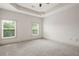 Light-filled carpeted bedroom features tray ceiling and neutral color scheme at 1199 Lavista Ne Rd, Atlanta, GA 30324