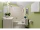 This bathroom has a tub shower, toilet, vanity and modern mirror and is painted a soft green at 6596 Wright Ne Rd, Atlanta, GA 30328