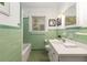 Charming bathroom with green tiling, vintage fixtures, and a well-lit vanity at 6596 Wright Ne Rd, Atlanta, GA 30328