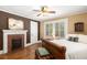 Bedroom featuring a fireplace with brick accents, neutral walls, and hardwood floors at 6596 Wright Ne Rd, Atlanta, GA 30328