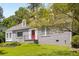 Well-maintained grey brick home featuring dormer windows, a red front door and lush green lawn at 6596 Wright Ne Rd, Atlanta, GA 30328