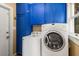 Functional laundry room with a white washer and dryer, and blue cabinets at 6596 Wright Ne Rd, Atlanta, GA 30328