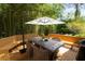 Relax on the wooden deck with custom benches, dining table, and umbrella surrounded by bamboo at 6596 Wright Ne Rd, Atlanta, GA 30328
