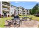Large backyard patio with outdoor seating, barbecue grill, and building view at 705 Berry Ct, Villa Rica, GA 30180