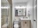 Bathroom featuring a walk-in shower with glass surround, and vanity with wooden cabinets at 705 Berry Ct, Villa Rica, GA 30180