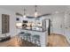 A bright kitchen with a breakfast bar, stainless steel appliances, white cabinetry, and hardwood floors for modern appeal at 705 Berry Ct, Villa Rica, GA 30180