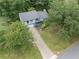 Aerial view of a charming home nestled among mature trees with a private driveway and lush landscaping at 9760 Loblolly Ln, Roswell, GA 30075