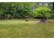 Private backyard featuring a wishing well, bench, and manicured lawn surrounded by mature trees at 9760 Loblolly Ln, Roswell, GA 30075