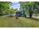 Spacious backyard with lush lawn, mature trees, and a cozy screened porch for outdoor enjoyment at 9760 Loblolly Ln, Roswell, GA 30075