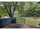 Wooden deck in a large, grassy backyard, surrounded by mature trees and a wooden fence at 9760 Loblolly Ln, Roswell, GA 30075