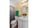 Cozy bathroom with a vanity, a shower with a curtain, a round mirror, and a towel rack at 9760 Loblolly Ln, Roswell, GA 30075