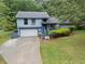Charming two-story home featuring a front yard, attached garage, and mature trees at 9760 Loblolly Ln, Roswell, GA 30075