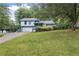 Charming blue two-story home with a well-maintained lawn and mature trees in the front yard at 9760 Loblolly Ln, Roswell, GA 30075