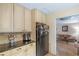 Efficient kitchen with black refrigerator, granite countertops, and access to the living room at 9760 Loblolly Ln, Roswell, GA 30075