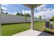 A covered back porch overlooks a large backyard with a white brick wall and A/C unit at 1818 Butterfly Way, Marietta, GA 30066