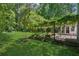 A lush green backyard with a vine covered patio at 3299 Pete Shaw Rd, Marietta, GA 30066