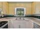 Sunlit kitchen features a double stainless sink, marble countertops, and decorative backsplash at 3299 Pete Shaw Rd, Marietta, GA 30066