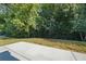 View of the home's backyard featuring lush, mature trees, and concrete patio at 3645 Ten Oaks Cir, Powder Springs, GA 30127