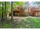 Exterior view of home with multiple decks and a spacious backyard surrounded by trees at 4905 Village Green Dr, Roswell, GA 30075