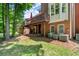 Home with a wooden deck and patio in a backyard surrounded by trees and well-maintained lawn at 4905 Village Green Dr, Roswell, GA 30075