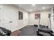 Basement with gym equipment and storage behind double doors, illuminated by recessed lighting at 4905 Village Green Dr, Roswell, GA 30075