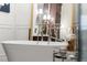 Luxurious bathroom featuring a freestanding soaking tub, decorative mirror, and elegant fixtures at 4905 Village Green Dr, Roswell, GA 30075