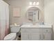Bright bathroom featuring a round mirror, granite vanity, and modern toilet at 4905 Village Green Dr, Roswell, GA 30075