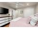 Bright bedroom featuring a ceiling fan, dark dresser, and flat screen television at 4905 Village Green Dr, Roswell, GA 30075