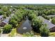 Scenic aerial view of the pond showcasing a tranquil water feature surrounded by lush greenery and townhomes at 4905 Village Green Dr, Roswell, GA 30075