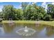 Picturesque view of a pond with a fountain, complemented by covered seating areas and mature trees at 4905 Village Green Dr, Roswell, GA 30075