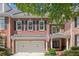 Charming brick home featuring a two-car garage, black shutters, and well-maintained landscaping at 4905 Village Green Dr, Roswell, GA 30075