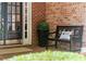 Inviting front porch featuring a bench, decor, and brickwork, next to the front door at 4905 Village Green Dr, Roswell, GA 30075
