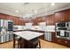 Modern kitchen with dark cabinets, stainless steel appliances, and a kitchen island with seating at 4905 Village Green Dr, Roswell, GA 30075