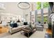 Open-concept living room with large windows, soaring ceilings, and a view to the dining area at 4905 Village Green Dr, Roswell, GA 30075