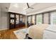 Bedroom with large mirrored wardrobe, ceiling fan, light colored bedding and desk with chair at 4905 Village Green Dr, Roswell, GA 30075