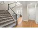 Carpeted staircase with white risers and dark wood handrail ascending to the upper level at 4905 Village Green Dr, Roswell, GA 30075