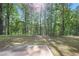 Lush backyard with a concrete patio overlooking a serene woodland at 115 Haven Brook Way, Douglasville, GA 30134