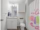 Well-lit bathroom features granite counters, white cabinets, and colorful shower curtain at 115 Haven Brook Way, Douglasville, GA 30134