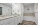 Well-lit bathroom with soaking tub, tiled floors, granite counters, and white cabinets at 115 Haven Brook Way, Douglasville, GA 30134