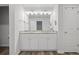 Well-lit bathroom featuring a double vanity, granite countertops, and wood look floors at 115 Haven Brook Way, Douglasville, GA 30134