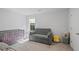 A room featuring a gray crib, sofa, chair, and carpet flooring at 115 Haven Brook Way, Douglasville, GA 30134