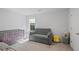 Cozy Bedroom featuring a small grey sofa, matching crib, and soft, plush carpet at 115 Haven Brook Way, Douglasville, GA 30134