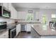 Open kitchen features stainless appliances, granite counters, and white subway tile backsplash at 115 Haven Brook Way, Douglasville, GA 30134