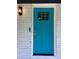 A vibrant blue front door with glass panes, complemented by white brick and modern lighting fixture at 3640 Narron Dr, Atlanta, GA 30331
