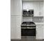 Close-up of kitchen featuring stainless steel appliances, white cabinets, and modern backsplash at 3640 Narron Dr, Atlanta, GA 30331
