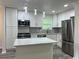 Modern kitchen featuring white cabinets, an island with marble countertop, stainless steel appliances, and modern lighting at 3640 Narron Dr, Atlanta, GA 30331