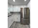 Updated kitchen featuring stainless steel refrigerator, white cabinets, grey backsplash, and countertop space at 3640 Narron Dr, Atlanta, GA 30331