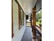 View of the home's covered porch, featuring wood accents and a black railing, offering a cozy outdoor space at 3640 Narron Dr, Atlanta, GA 30331